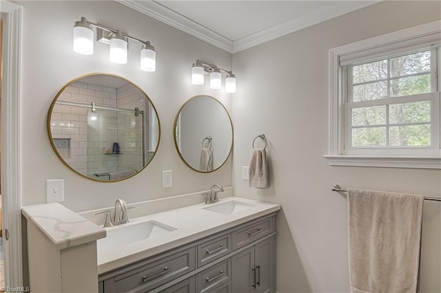bathroom with double vanity, a tile shower, ornamental molding, and a sink