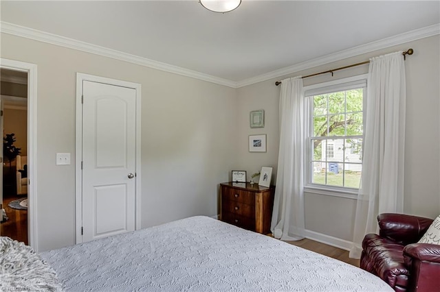 bedroom featuring wood finished floors, baseboards, and ornamental molding