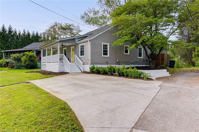 view of front of home with a front lawn, a porch, driveway, and ceiling fan