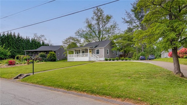 single story home featuring a front lawn, a porch, and driveway