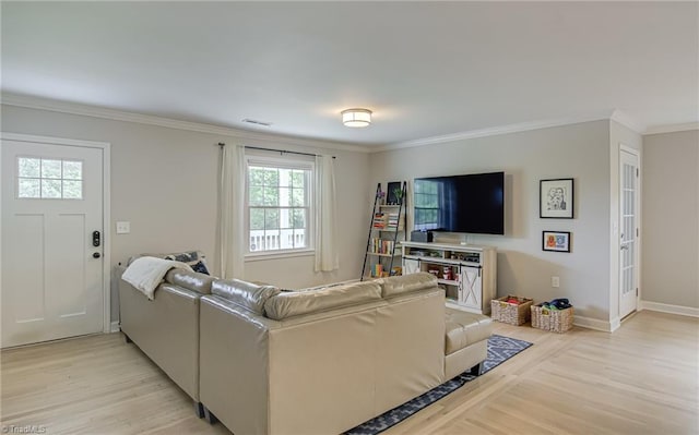 living room with ornamental molding, light wood-style flooring, baseboards, and visible vents