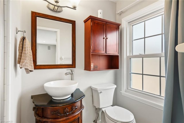 bathroom with a healthy amount of sunlight, toilet, and vanity