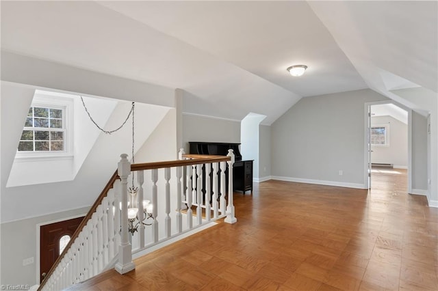 additional living space featuring lofted ceiling and a baseboard heating unit