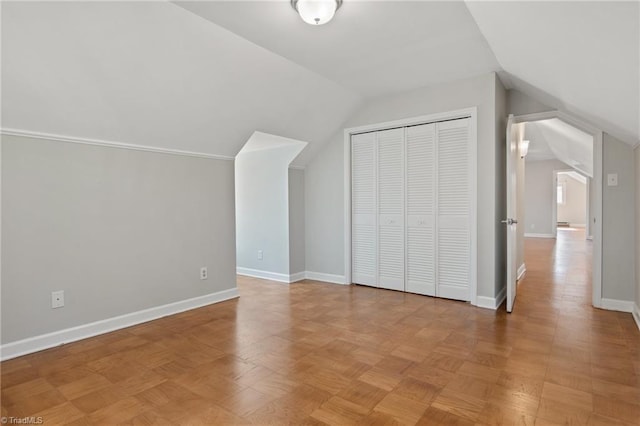 additional living space featuring light parquet floors and vaulted ceiling