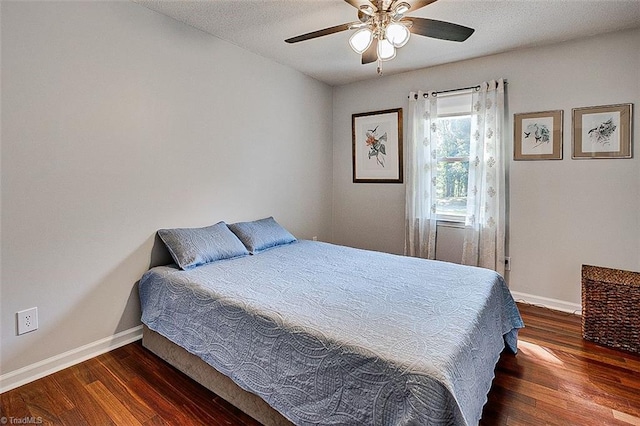 bedroom featuring a textured ceiling, ceiling fan, and dark wood-type flooring