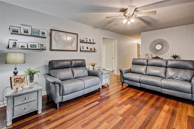 living room with ceiling fan, a textured ceiling, and dark hardwood / wood-style floors