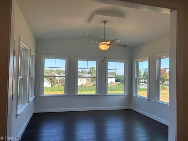 unfurnished sunroom featuring ceiling fan, vaulted ceiling, and a healthy amount of sunlight