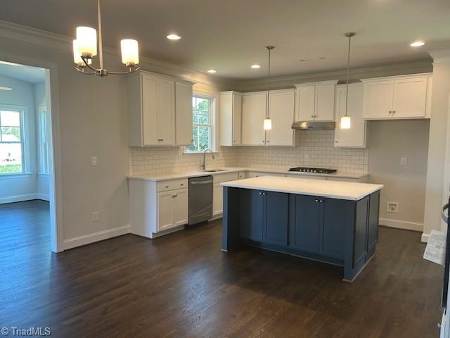 kitchen with hanging light fixtures, white cabinets, dishwasher, and a kitchen island