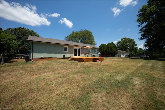 rear view of property with a yard and a wooden deck