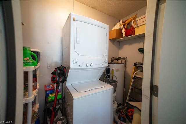 laundry area with a textured ceiling, gas water heater, and stacked washer / drying machine