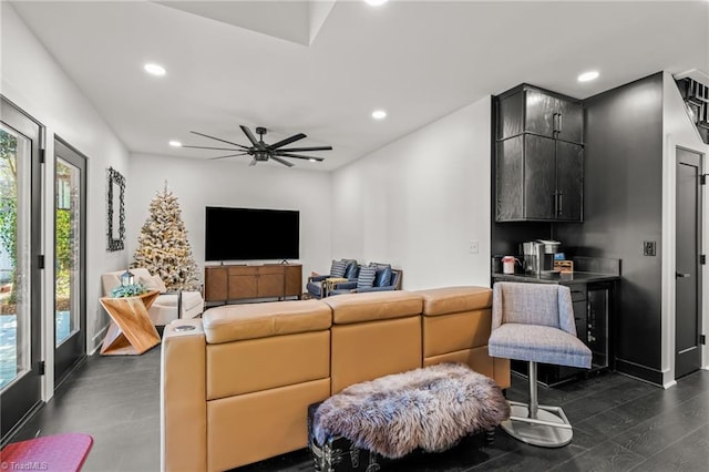 living room featuring ceiling fan, a wealth of natural light, and dark hardwood / wood-style flooring