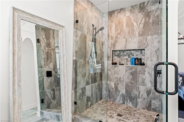 bathroom featuring a shower with door