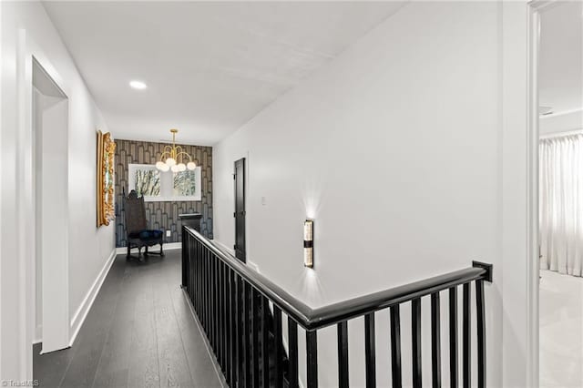 corridor featuring dark wood-type flooring and a chandelier