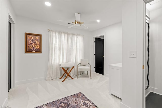 interior space with ceiling fan and light colored carpet