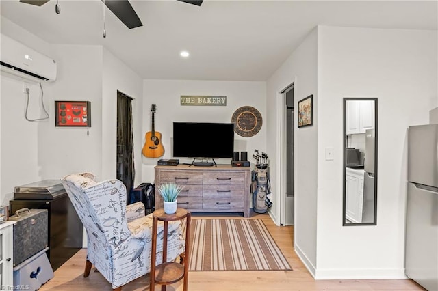 living room with ceiling fan, light wood-type flooring, and a wall unit AC