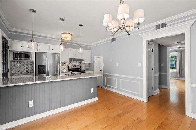 319 Hanover Arms Ct, Winston-Salem, NC 27104 - kitchen featuring stainless steel appliances, decorative backsplash, under cabinet range hood, white cabinets, and light wood-style flooring