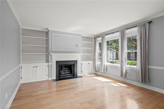 319 Hanover Arms Ct, Winston-Salem, NC 27104 - unfurnished living room with crown molding, baseboards, light wood-type flooring, a fireplace with flush hearth, and built in shelves