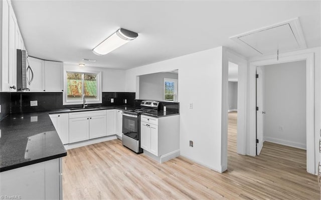 kitchen with backsplash, white cabinetry, stainless steel range with electric cooktop, and sink