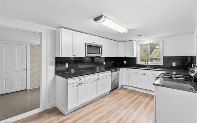 kitchen featuring white cabinets, light hardwood / wood-style floors, sink, and stainless steel appliances