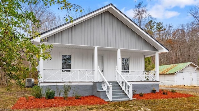 view of front of property featuring central AC, covered porch, and a shed