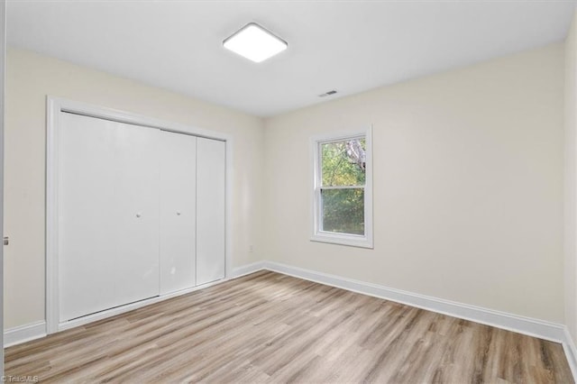 unfurnished bedroom featuring a closet and light hardwood / wood-style flooring