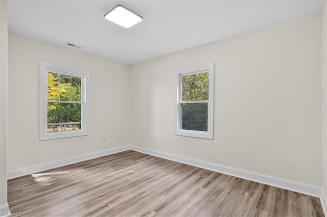 unfurnished room featuring plenty of natural light and light hardwood / wood-style floors