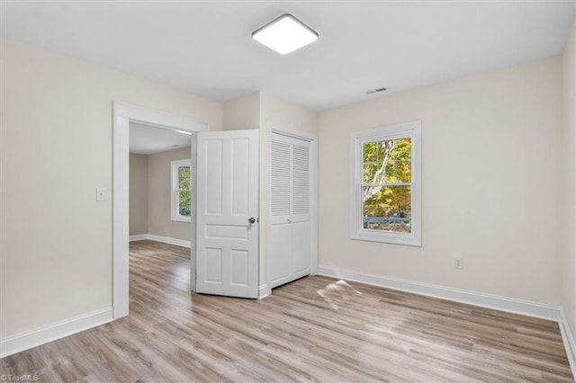 unfurnished bedroom featuring light wood-type flooring and a closet