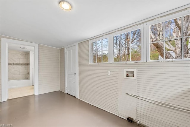 laundry room with wood walls and washer hookup