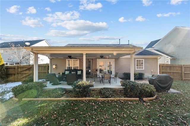 rear view of property featuring a patio area, french doors, ceiling fan, a yard, and an outdoor living space