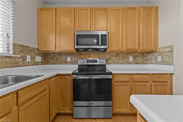 kitchen featuring sink, appliances with stainless steel finishes, and tasteful backsplash