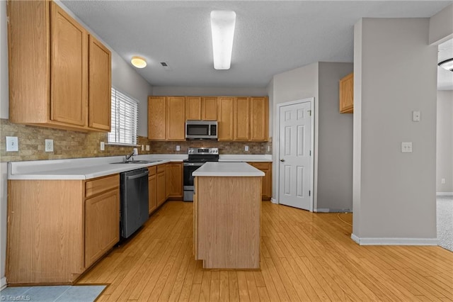 kitchen featuring decorative backsplash, a kitchen island, sink, and stainless steel appliances