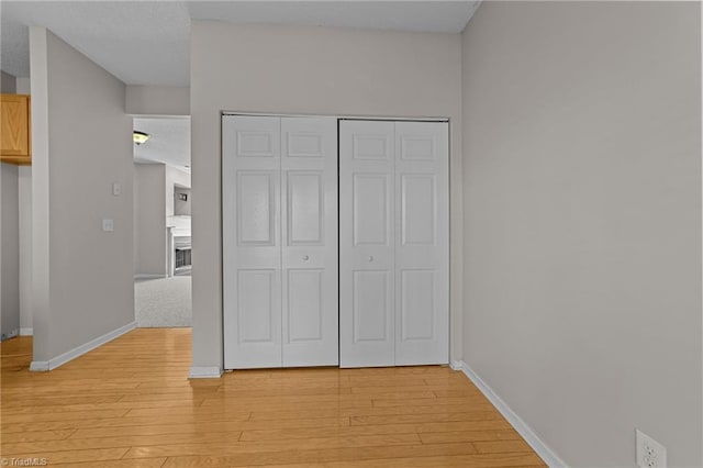 unfurnished bedroom featuring a closet and light hardwood / wood-style floors