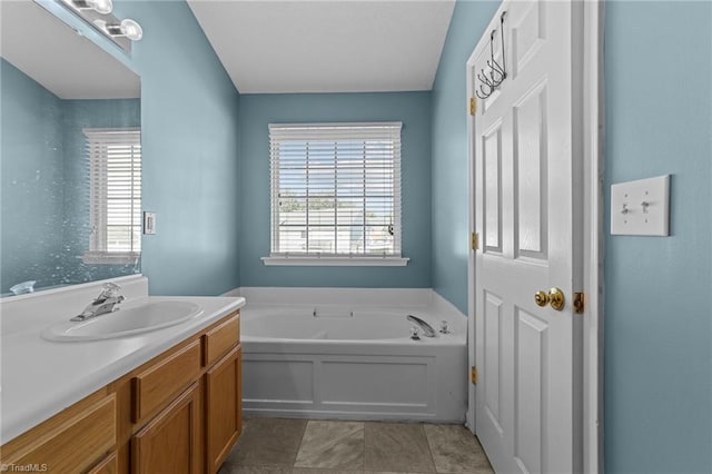 bathroom with tile patterned floors, a bathing tub, and vanity