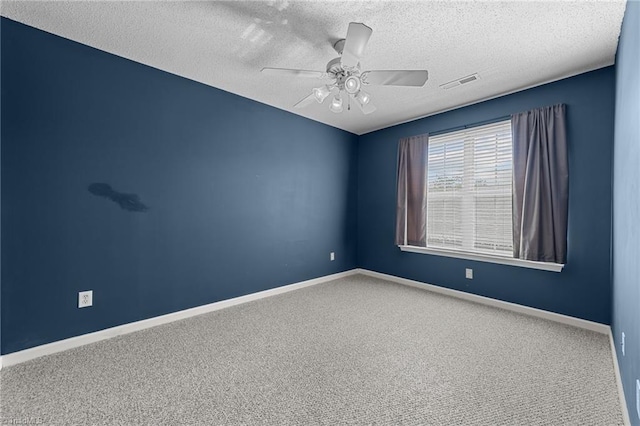 spare room featuring carpet flooring, ceiling fan, and a textured ceiling