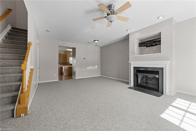 unfurnished living room featuring light colored carpet and ceiling fan