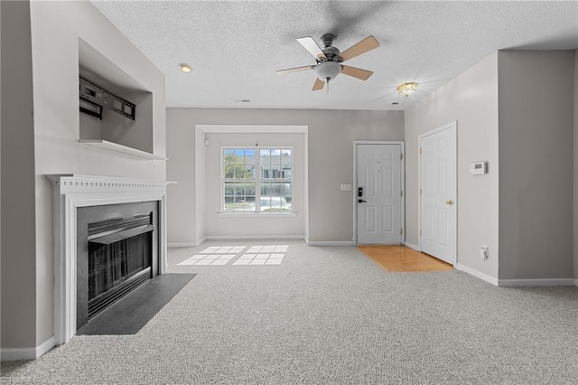 unfurnished living room featuring ceiling fan, carpet, and a textured ceiling