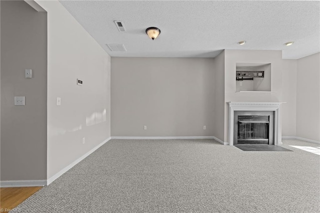 unfurnished living room featuring light carpet and a textured ceiling