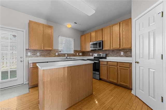 kitchen with backsplash, a center island, sink, and stainless steel appliances