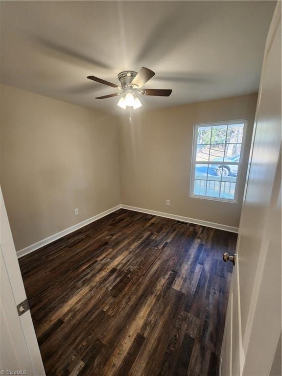 empty room with dark hardwood / wood-style floors and ceiling fan