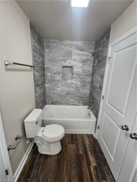 bathroom with toilet, tiled shower / bath combo, and hardwood / wood-style flooring