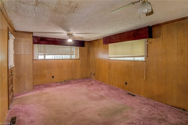 1900 Peachtree St, Winston-Salem, NC 27107 - empty room with ceiling fan, wooden walls, a textured ceiling, carpet flooring, and ornamental molding