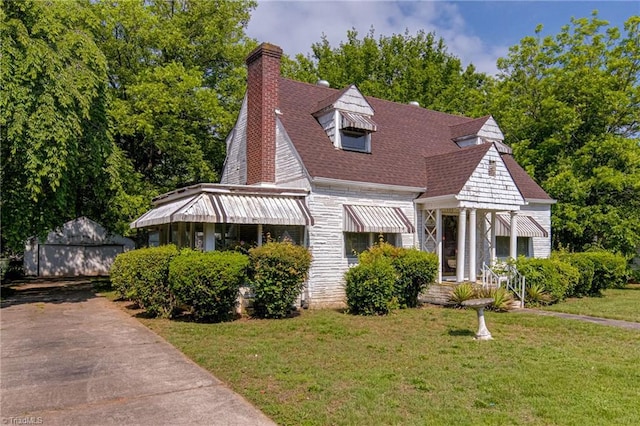 1900 Peachtree St, Winston-Salem, NC 27107 - view of front facade with a front lawn, an outdoor structure, a chimney, a shingled roof, and stone siding