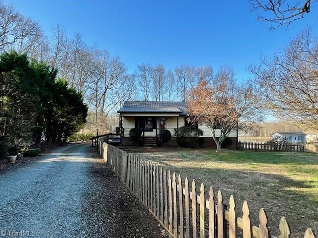 view of side of property featuring fence and a lawn