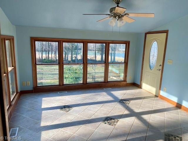 interior space with baseboards, ceiling fan, visible vents, and tile patterned floors