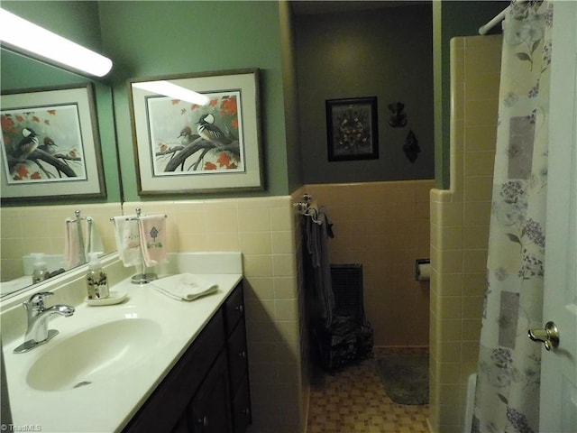 bathroom featuring vanity, a shower with shower curtain, and tile walls