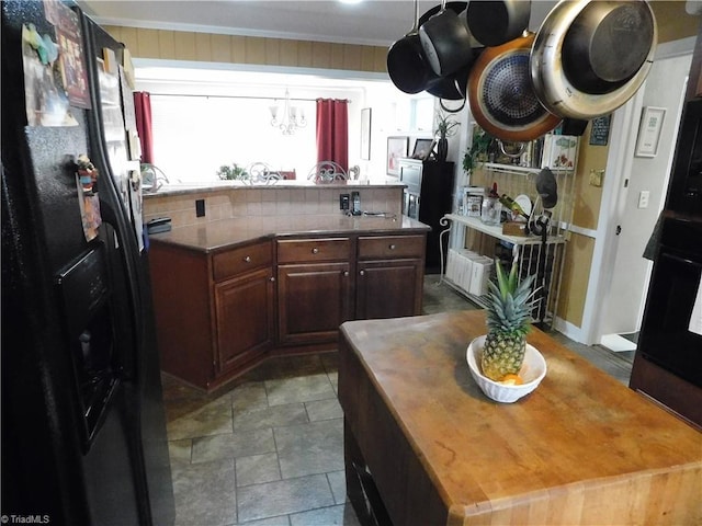 kitchen featuring dark brown cabinetry, wooden counters, and black fridge with ice dispenser