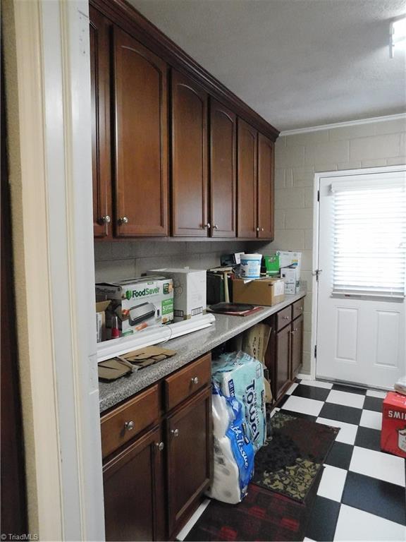 kitchen featuring dark brown cabinetry and crown molding