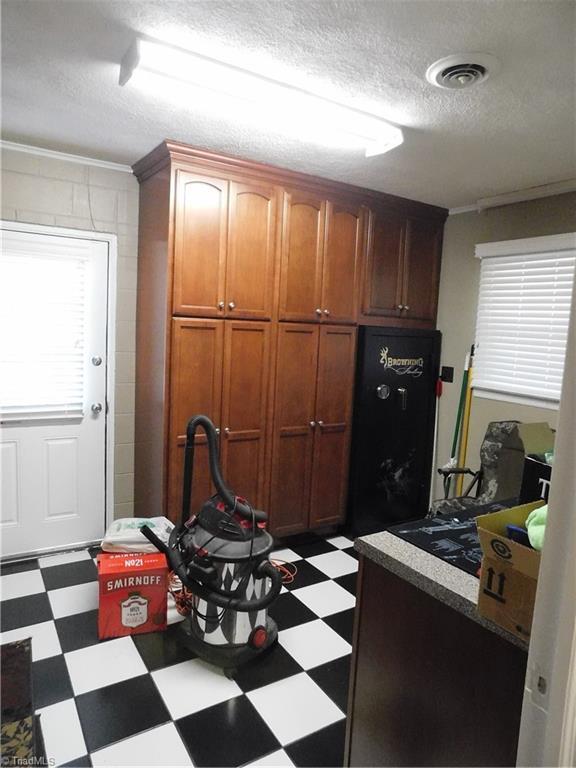 kitchen with crown molding, a healthy amount of sunlight, and a textured ceiling