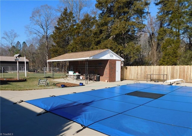 view of pool with a patio, a diving board, and an outbuilding