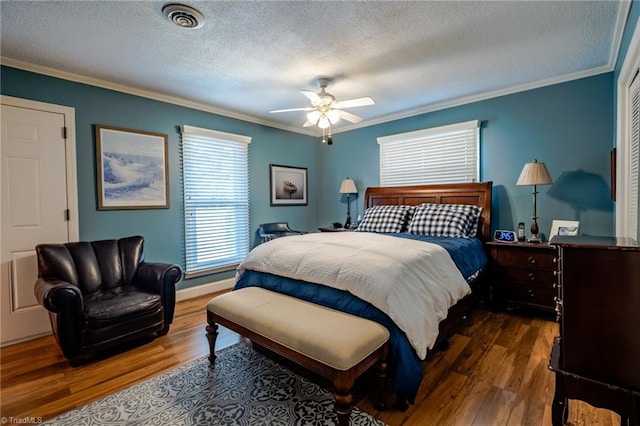 bedroom with ornamental molding, dark hardwood / wood-style floors, and a textured ceiling